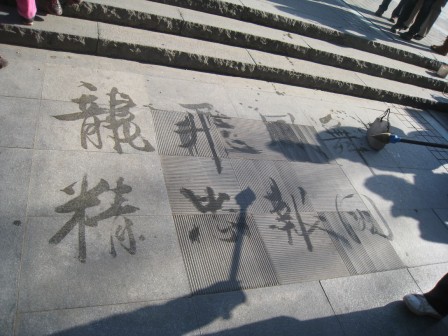 Caractères chinois tracés au sol avec de l'eau par un vieil homme à Pékin